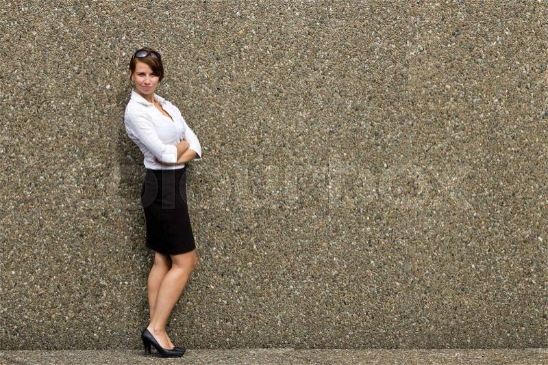 Portrait of a young attractive business woman against grey wall - copy space, stock photo