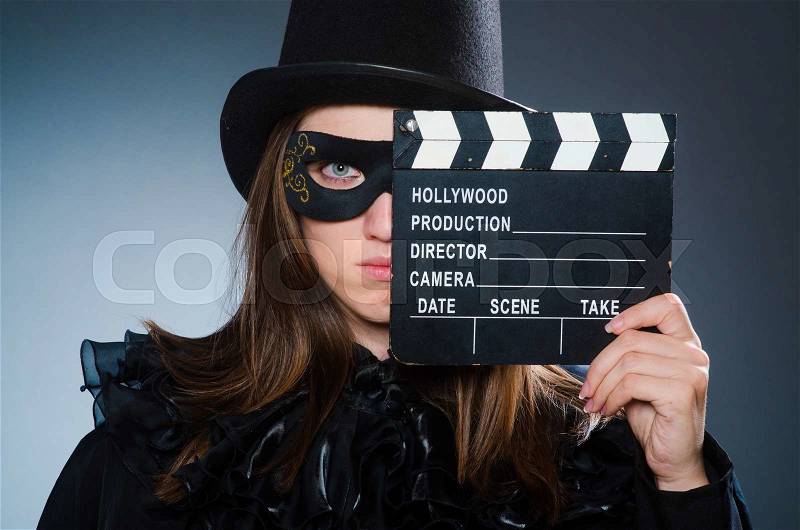 Woman wearing mask with movie board, stock photo