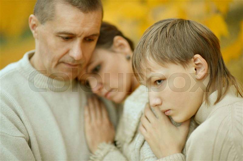 Portrait of a sad family of three on the nature, stock photo