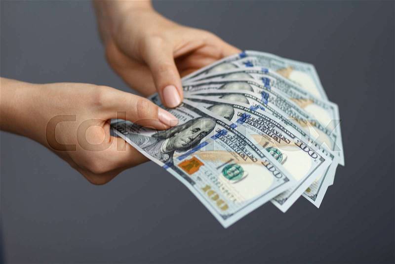 Fan of 100 dollar banknotes in beautiful woman hands, stock photo