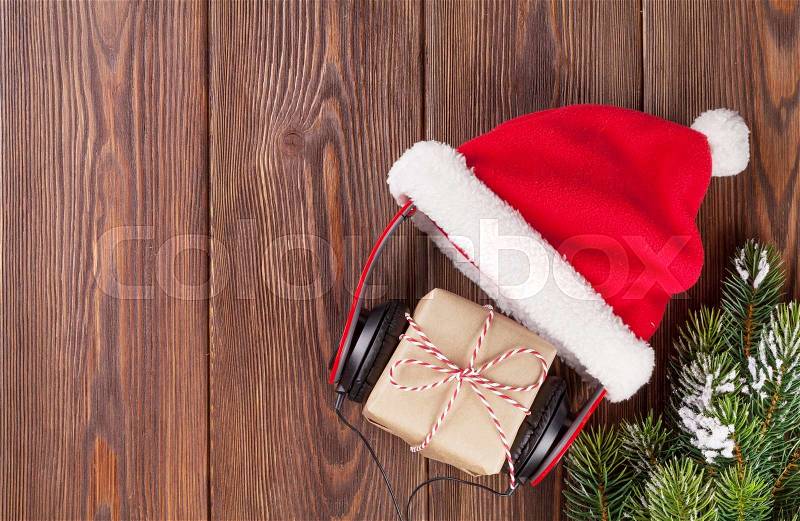 Christmas gift box with headphones and santa hat on wooden table. Top view with copy space, stock photo