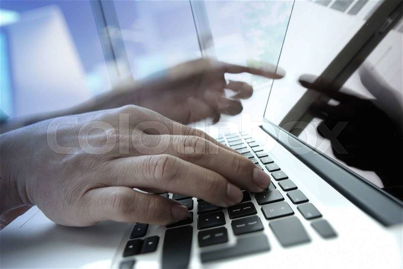 Double exposure of business man hand working on blank screen laptop computer on wooden desk as concept, stock photo