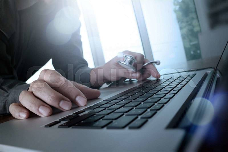 Doctor working at workspace with laptop computer in medical workspace office, stock photo