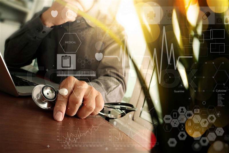 Doctor working at workspace with laptop computer in medical workspace office and digital medical layers diagram with green plant foreground , stock photo