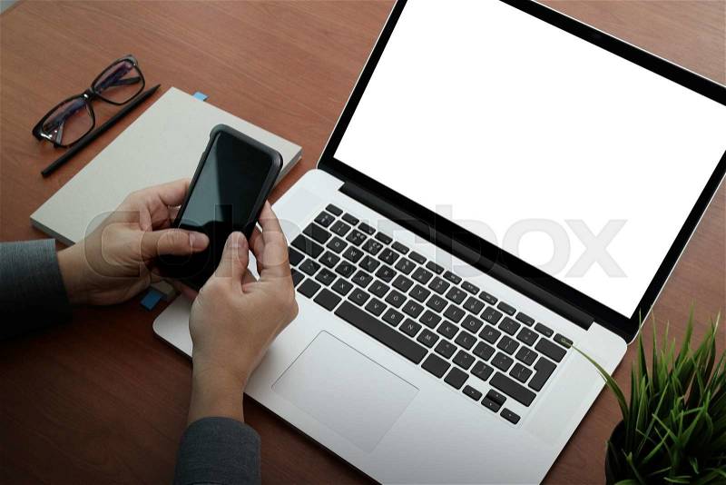 Top view of businessman hand using on smart phone and laptop computer as concept, stock photo