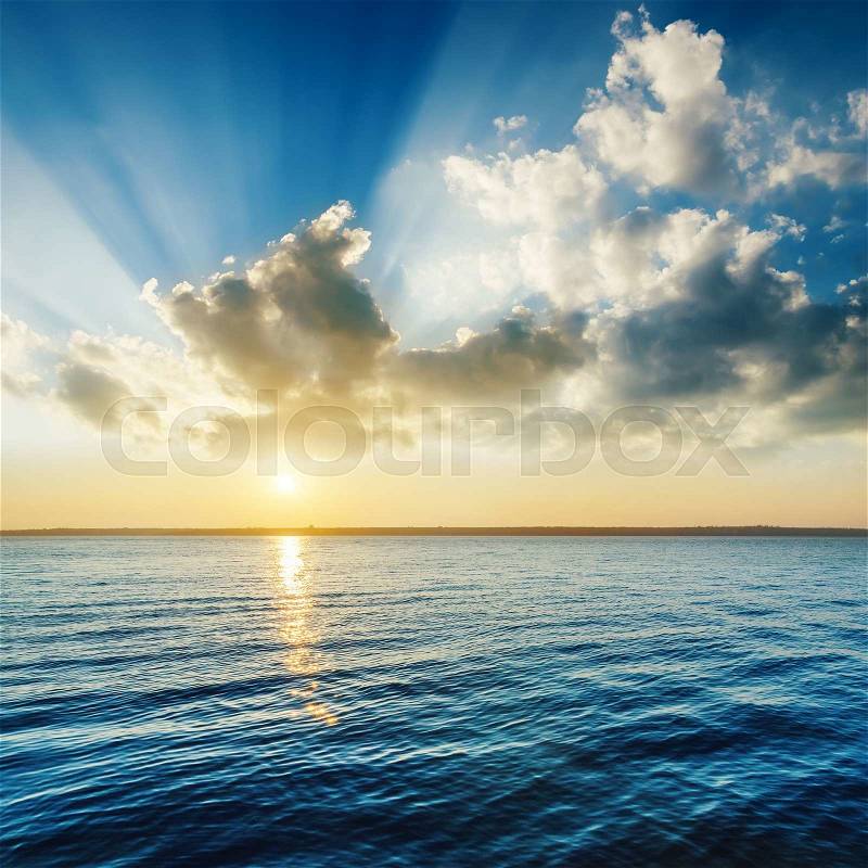 Cloudy sunset over dark river, stock photo