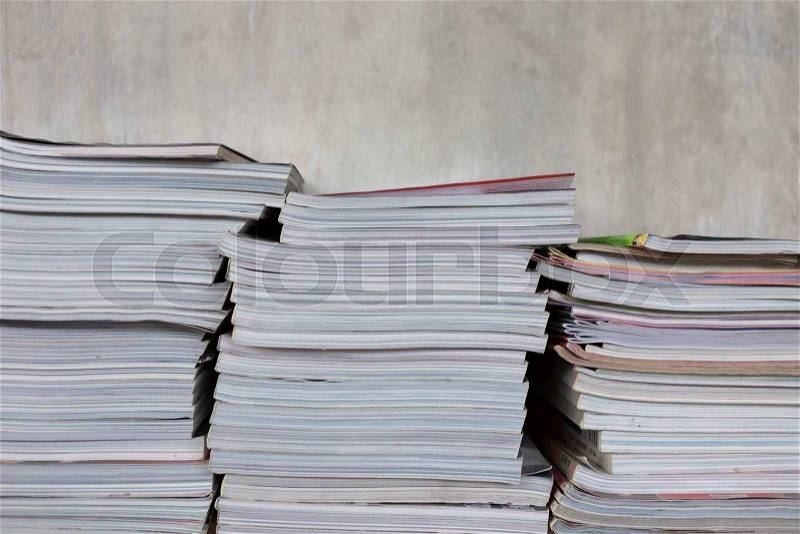 Magazines on table book shelf with cement mortar wall, stock photo