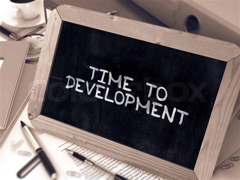 Time to Development. Inspirational Quote Hand Drawn on Chalkboard on Working Table Background. Blurred Background. Toned Image, stock photo