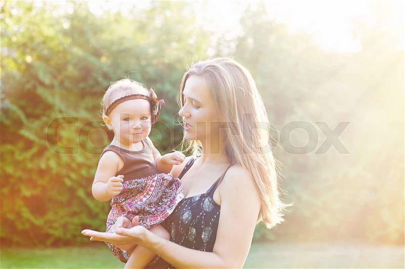 Mother and lovely daughter at sunny park. Happy family concept, stock photo