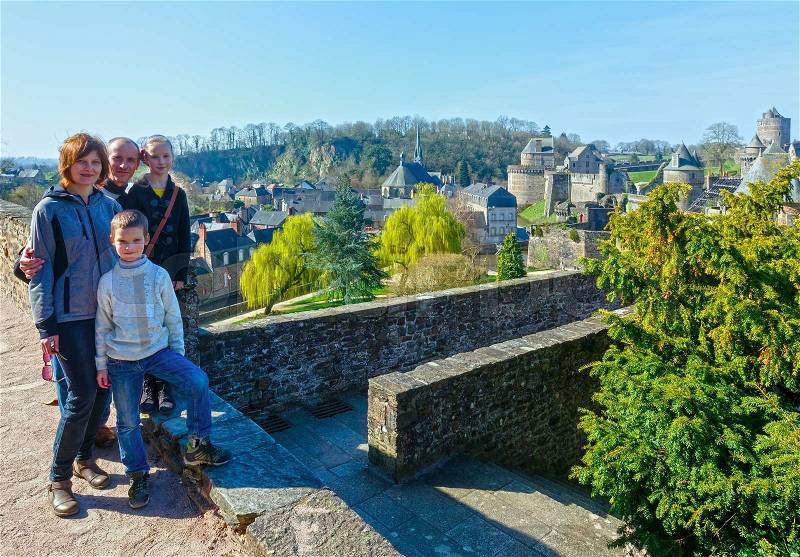 Family on spring holidays in France. On the right Chateau de Fougeres (build in XII-XV centuri), stock photo