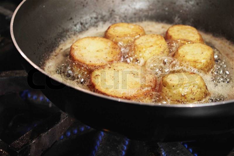 Potatoes frying in pan, stock photo