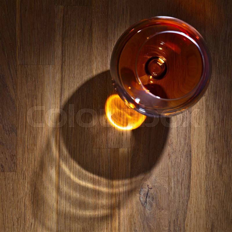 Snifter of brandy on a old wooden table, stock photo