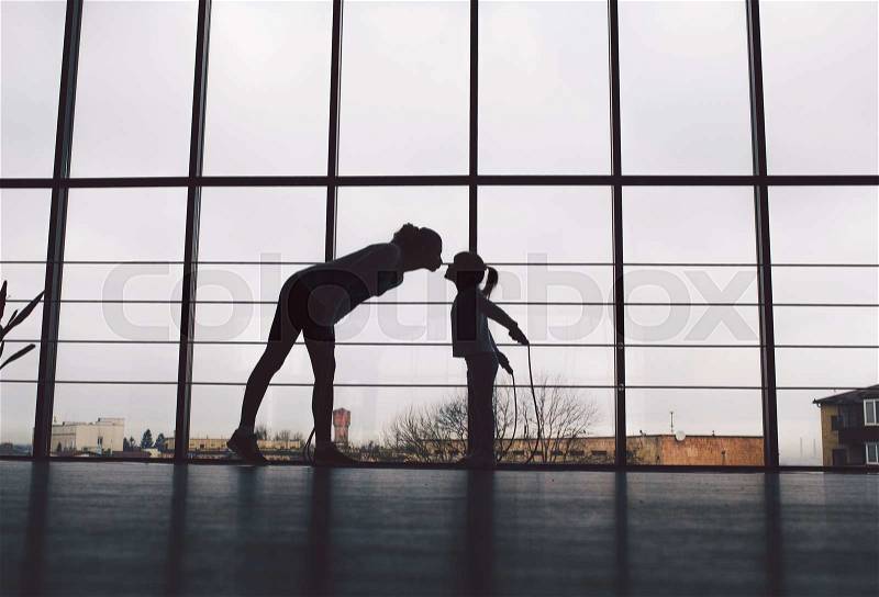 Silhouette of mother and daughter in the gym.Kiss, stock photo