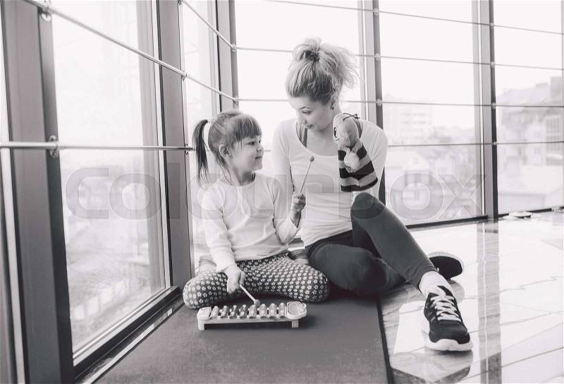 Mother and daughter playing with toys in the gym, stock photo