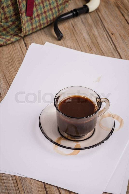 Coffee cup, paper sheets and detective hat on old Wooden table, stock photo