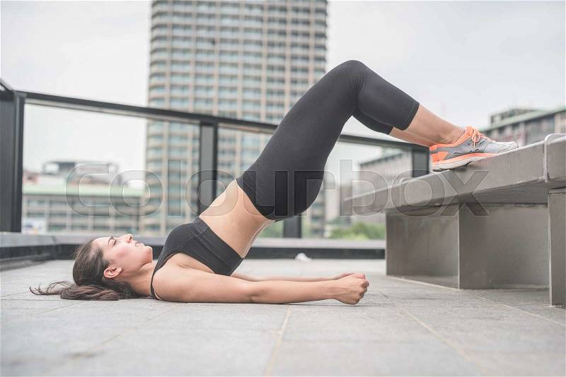 Young handsome caucasian brown hair sportive woman doing abdominals lifting her legs, fists closed, under strain - sportive, fitness, healthy, training concept, stock photo