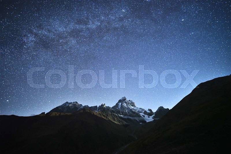 Night landscape. Starry sky with the Milky Way over the mountains. Mount Ushba in the light of the rising moon. Main Caucasian ridge. Zemo Svaneti, Georgia , stock photo