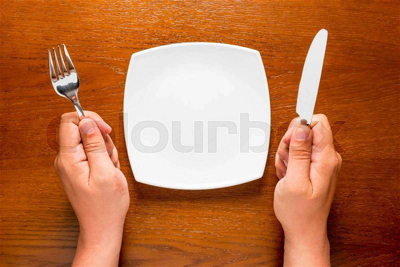 Hungry man with empty plate ready for dinner, stock photo