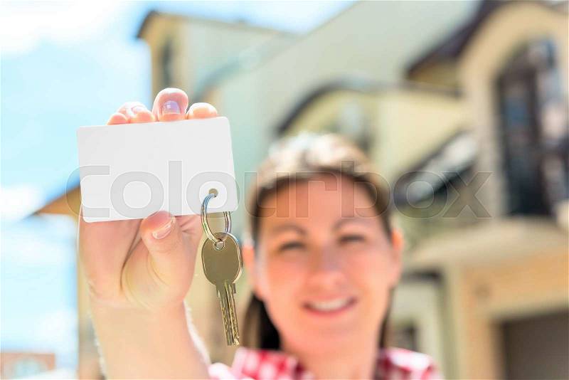 Card with a key in hand of happy woman. focus on the key, stock photo