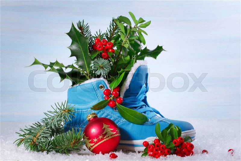 Blue shoe with Holly leaves and berries. Christmas background, stock photo