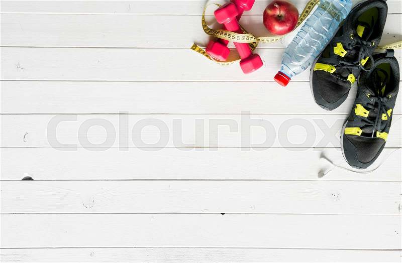 Fitness items on wooden planks background top view with text space, stock photo