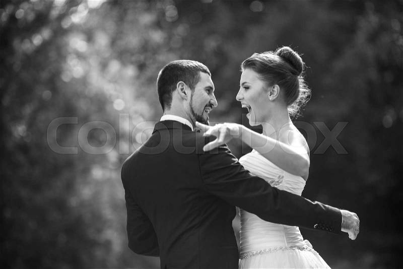 Beautiful wedding couple in each other\'s arms in the park, close angle, stock photo