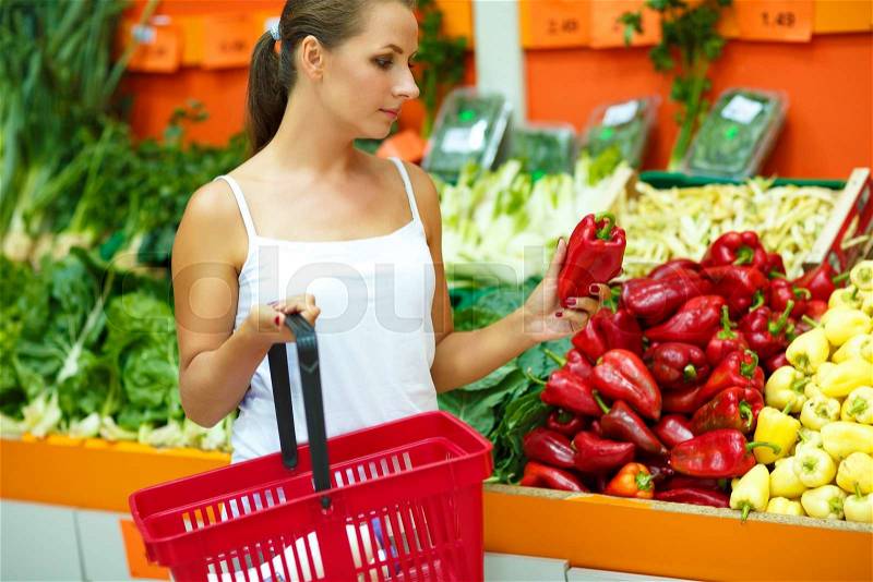 Young beautiful woman shopping in a supermarket in the department of fruit and vegetables, stock photo