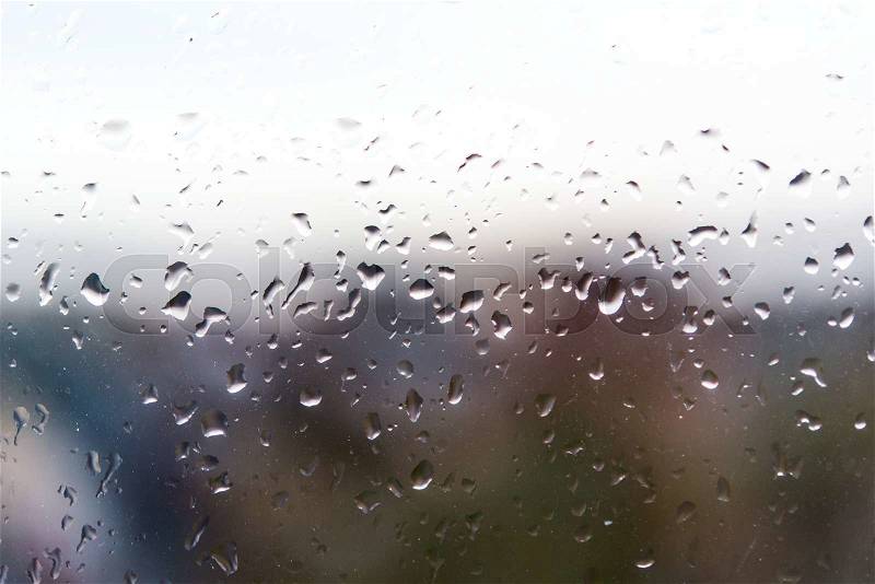 Drops of rain on the train window with tree in background, stock photo