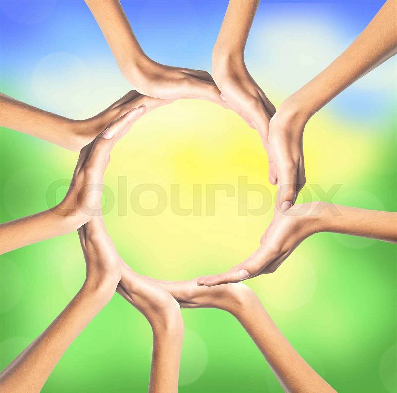 Group of young people\'s hands over bright nature background, stock photo