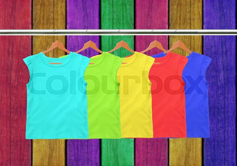 Clothes on circle hanger over painted wooden planks background, stock photo
