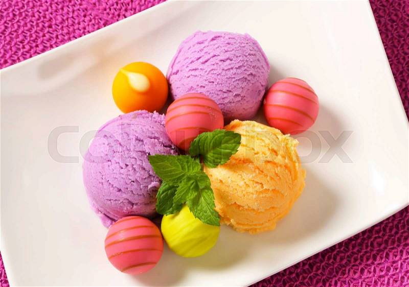 Fruit-flavored ice cream and white chocolate bonbons with fruit ganache filling, stock photo