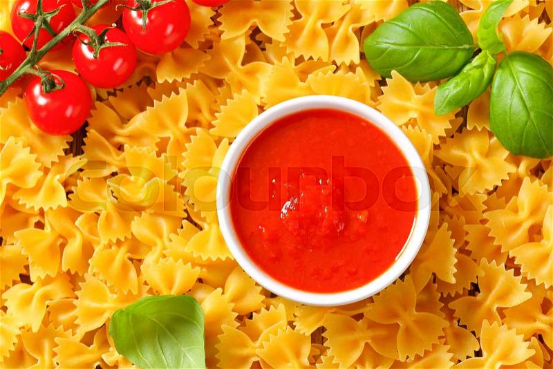 Uncooked bow tie pasta and tomato puree, stock photo