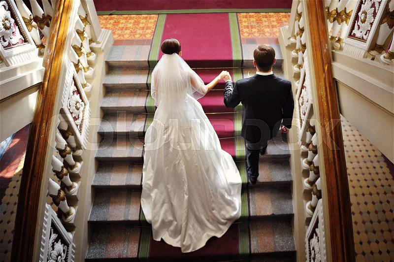 Bride and groom walk up the stairs. top view, stock photo