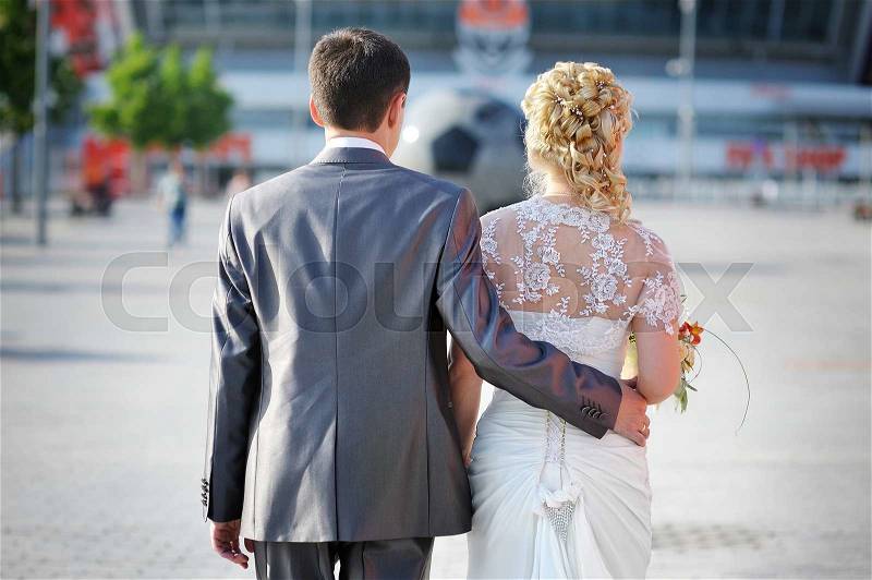Bride and groom walking on the boulevard, stock photo