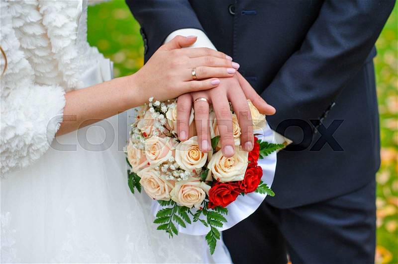 Bridal bouquet close up in the hands of the bride and groom, stock photo