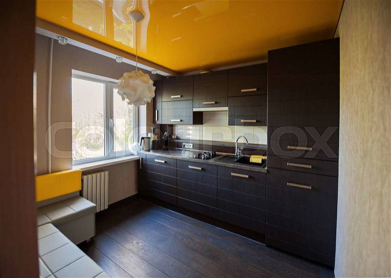 Beautiful designer kitchen in brown and yellow colors, stock photo