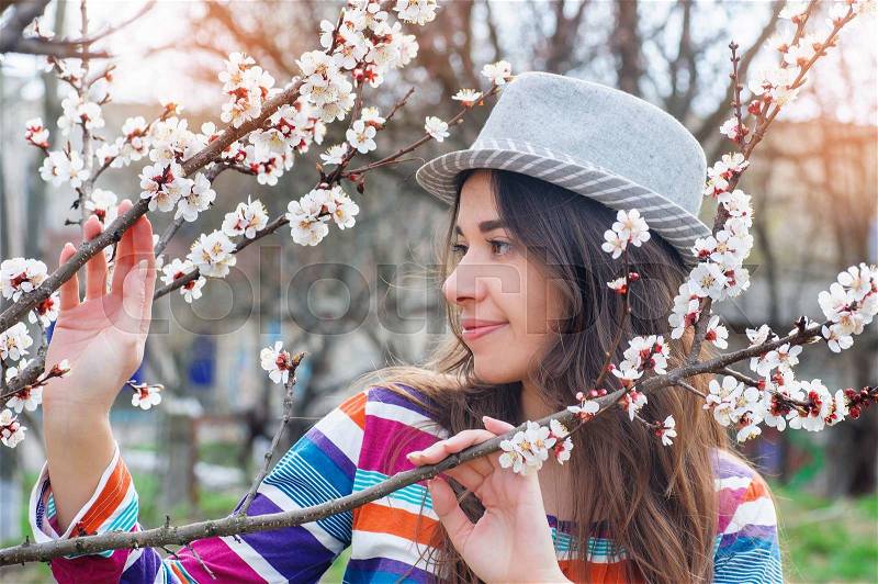 Woman in spring blossom. Young naturally beautiful woman near the blooming tree in spring time, stock photo