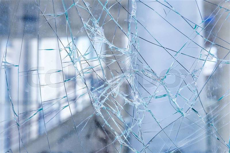 Cracked glass in a shop window closeup, stock photo
