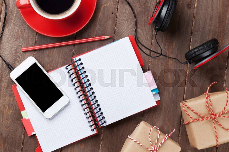 Office wooden desk with notepad, smartphone and gift boxes. Top view with copy space, stock photo