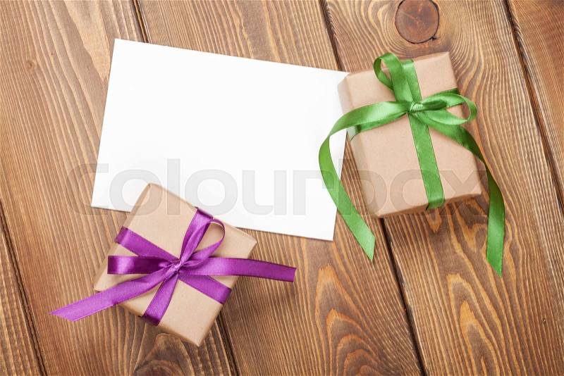 Photo frame card and gift boxes with ribbon over wooden table background, stock photo