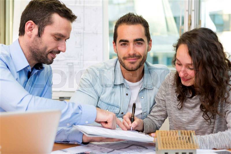 View of a Young attractive people signing cotract with meeting real estate agent, stock photo