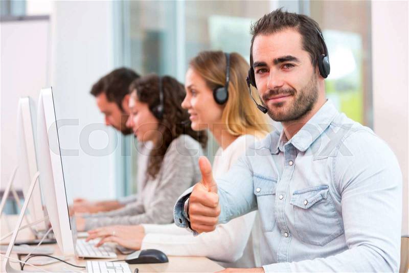 View of a Young attractive man working in a call center, stock photo