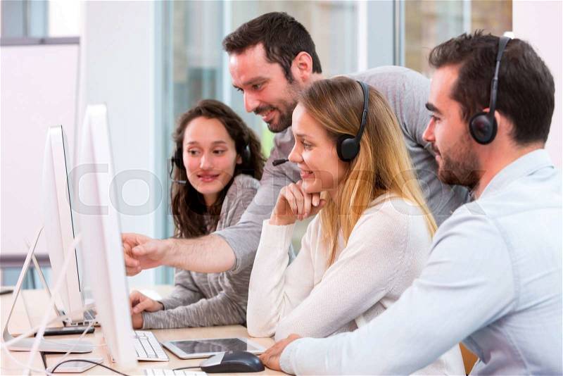 View of a Young attractive people learning their new job at call center , stock photo