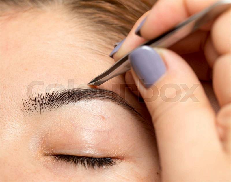 Grooming the eyebrows in a beauty salon, stock photo
