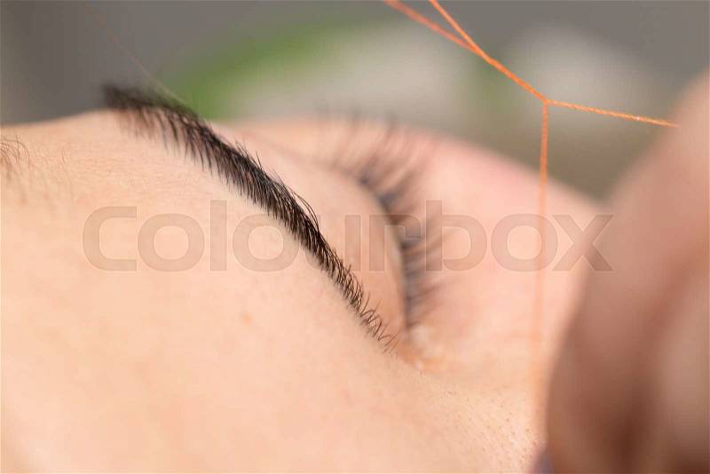Grooming the eyebrows thread in a beauty salon. close, stock photo