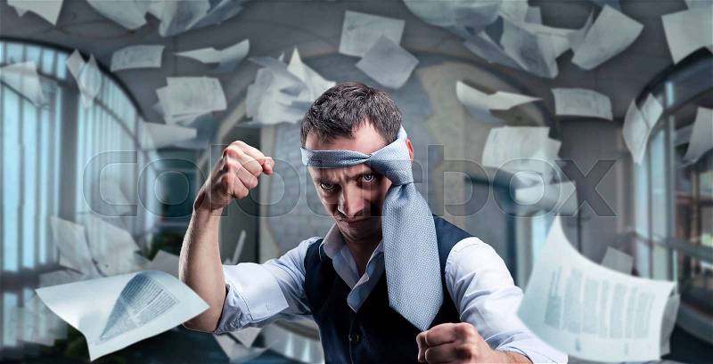 Fighting businessman with a tie on his head in the office, stock photo