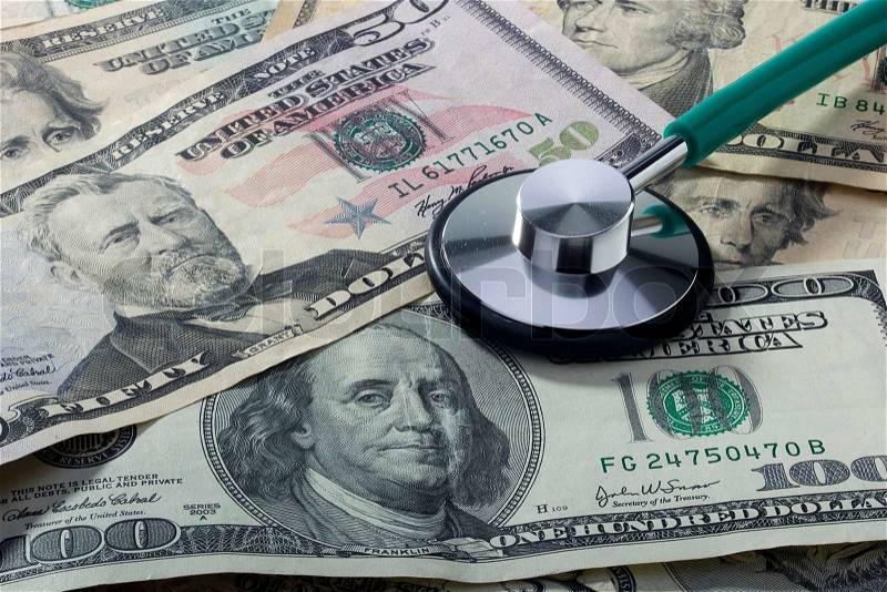 Medical stethoscope laying on various denominations of American money, stock photo