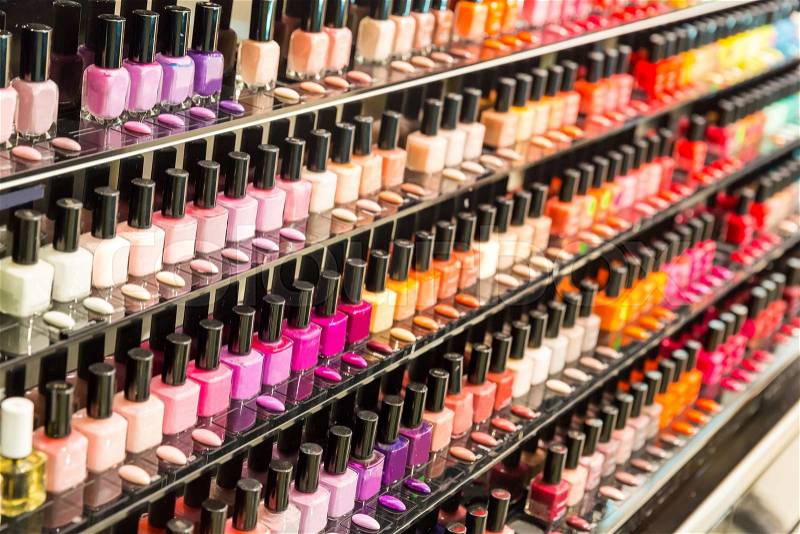 Set of different nail varnishes on shelves in cosmetic store, stock photo