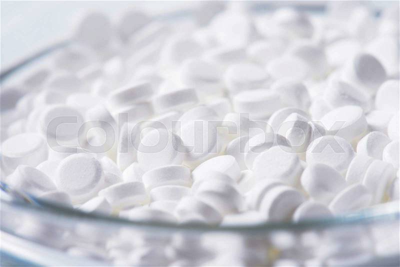 Artificial sweetener tablets in glass bowl, stock photo