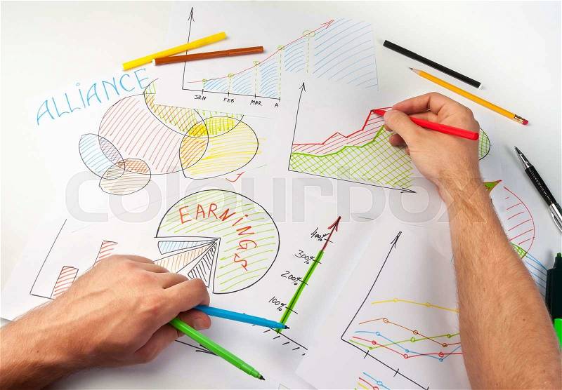 Man painting business diagrams on papers with soft-tip pen, stock photo